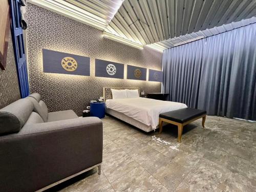 a bedroom with a bed and a couch at 九號行館No9 Hotel in Changhua City