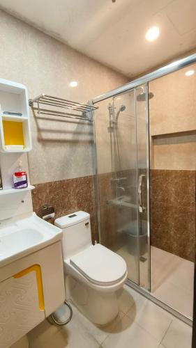 a bathroom with a toilet and a glass shower at Baguio Transient 6F-9 Megatower Residences II in Baguio