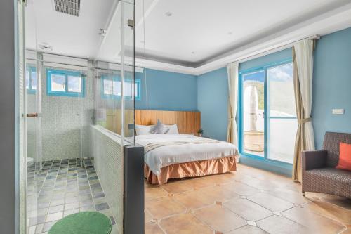 a bedroom with a bed and a glass shower at Kenting Shen's Homestay in Eluan