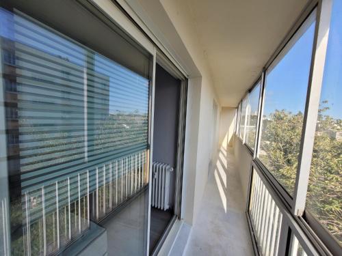 - un balcon avec de grandes fenêtres dans un bâtiment dans l'établissement Appartement T4, à Brest