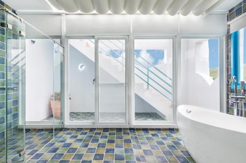 a bathroom with a tub and glass doors and a staircase at Kenting Shen's Homestay in Eluan