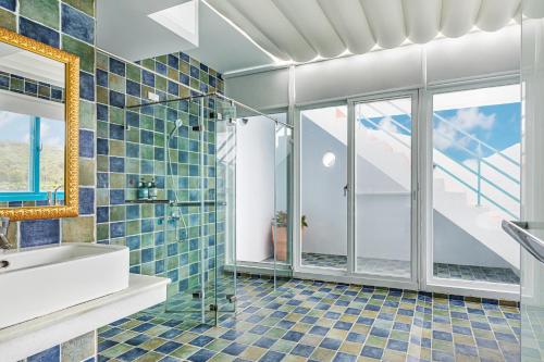 a bathroom with a sink and a shower with blue tiles at Kenting Shen's Homestay in Eluan