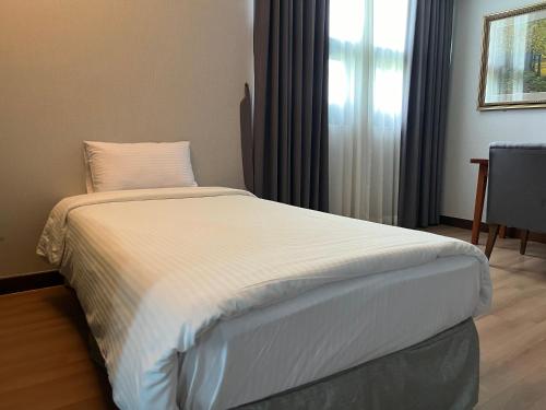 a large bed in a room with a window at Sacheon Grand Tourist Hotel in Sacheon