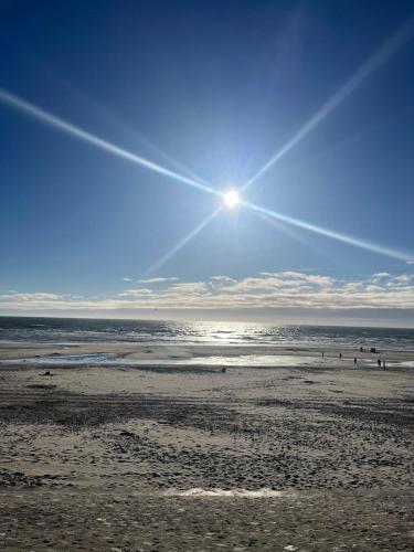 a view of a beach with people in the water at L Orée de la Pinède Hardelot Plage à 800 metres de la mer sous les pins in Hardelot-Plage