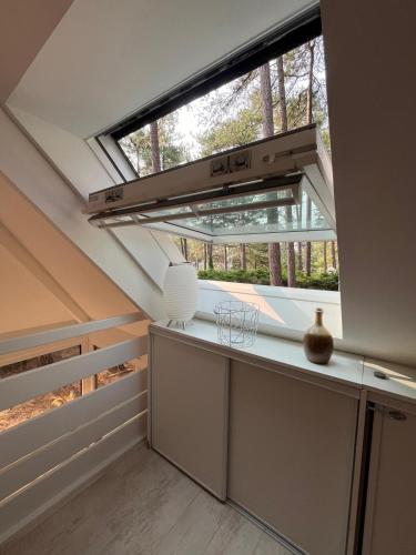 an attic kitchen with a large window and a desk at L Orée de la Pinède Hardelot Plage à 800 metres de la mer sous les pins in Hardelot-Plage