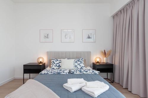 una camera da letto con un letto blu con asciugamani sopra di Apartly - Hanza Tower apartament City View, parking, pool, sauna a Stettino