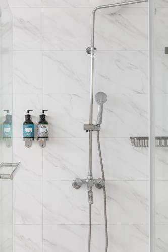a shower with two bottles ofodorizers on the wall at Kenting Shen's Homestay in Eluan