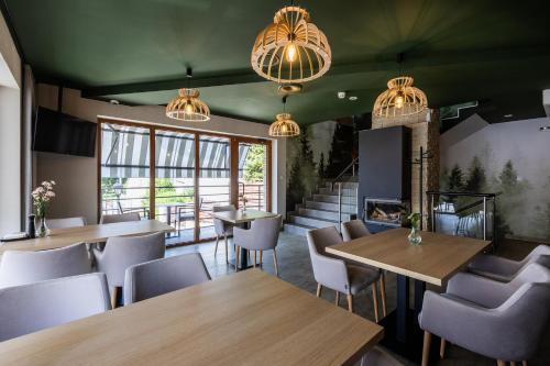 a restaurant with tables and chairs and a fireplace at Przystań Leśniów in Żarki