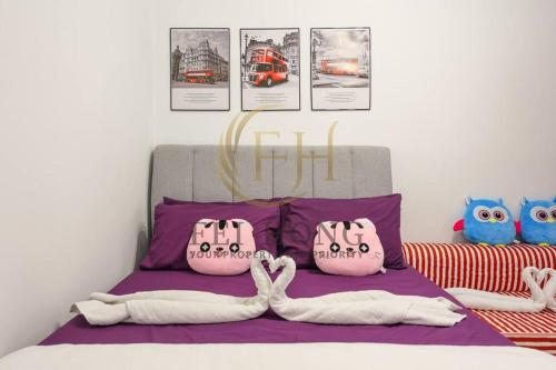 a bedroom with a bed with purple sheets and posters at Serdang Resort-Style Family Suite #Babycot #15 Pax in Seri Kembangan