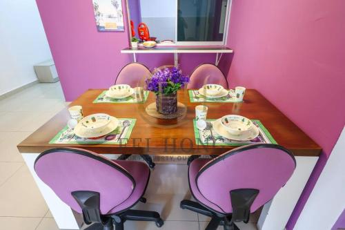 a table with purple chairs and a purple wall at Serdang Resort-Style Family Suite #Babycot #15 Pax in Seri Kembangan