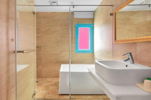a bathroom with a sink and a tub and a window at Kenting Shen's Homestay in Eluan