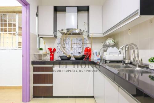 a kitchen with white cabinets and a sink at Serdang Resort-Style Family Suite #Babycot #15 Pax in Seri Kembangan