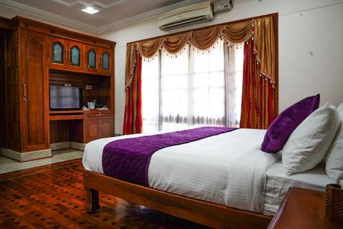 Un dormitorio con una cama grande y una ventana. en Parvathy Serenity In Varkala, en Attingal
