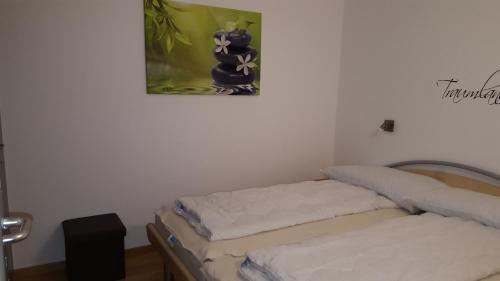 2 Betten in einem Zimmer mit einem Bild an der Wand in der Unterkunft Alpen-Fewo, Residenza Quadra 225 in Flims