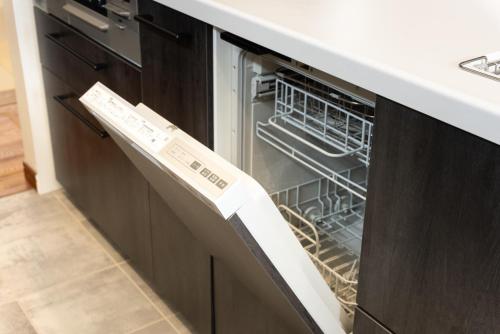 an open dishwasher with its door open in a kitchen at Villa Ray Miyakojima in Hirara