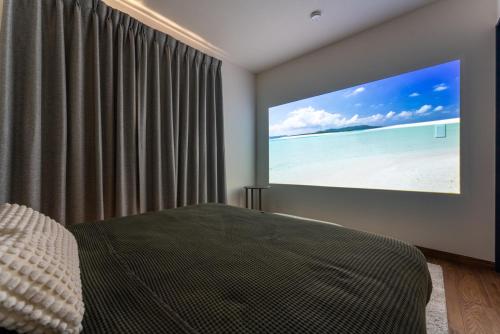 a bedroom with a projection screen on the wall at Villa Ray Miyakojima in Hirara
