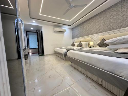 a hotel room with two beds and a window at Hotel Krishna Deluxe-By RCG Hotels in New Delhi