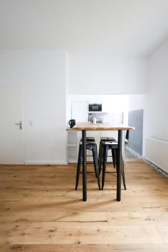 a table with four chairs in a room with a white wall at Apartment mit Garage und Balkon nähe Europapark in Offenburg