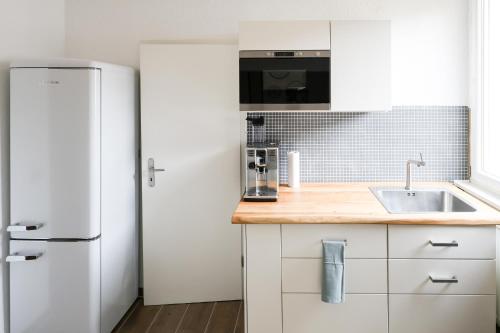 a kitchen with a white refrigerator and a sink at Apartment mit Garage und Balkon nähe Europapark in Offenburg