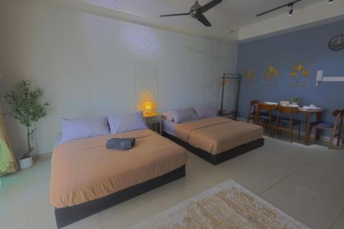 a bedroom with two beds and a table and a dining room at Aurora Staycation I-City Shah Alam in Kampong Padang Jawa