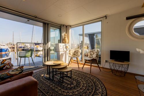 a living room with a view of a boat at Home of the Houseboat - Zen in Dinteloord