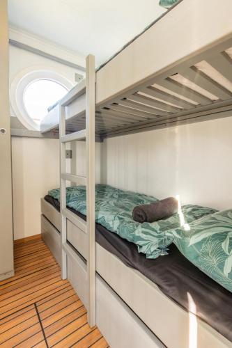 two bunk beds in a room with a window at Home of the Houseboat - Zen in Dinteloord