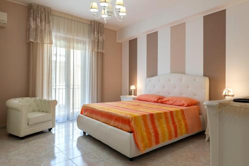 a bedroom with a bed and a chair at Casa Vacanze Francesco Pulsano in Pulsano