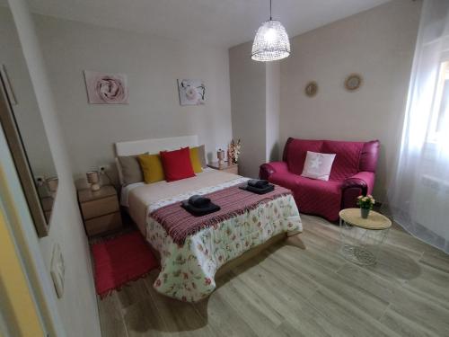 a bedroom with a bed and a pink couch at Lembranzas in Padrón