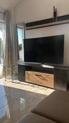 a large entertainment center with a large flat screen tv at Two Rooms Apartment near S8 line in Munich