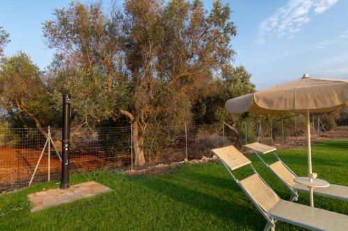 an umbrella and two chairs and a table with an umbrella at Bellavita and pool in Brindisi