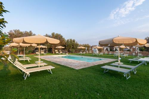 a swimming pool with umbrellas and lounge chairs next to a pool at Bellavita and pool in Brindisi
