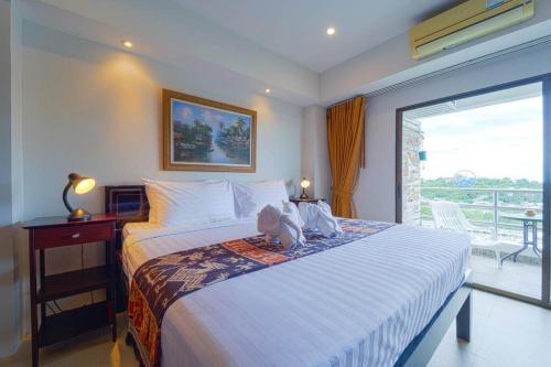 a bedroom with a large bed and a balcony at Beachfront 2 bed Condo with Seaview! - BW2 in Hua Hin