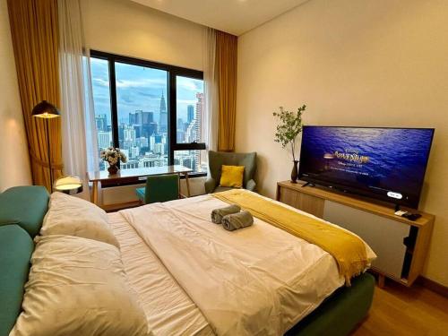 a hotel room with a bed and a flat screen tv at Studio with Amazing KLCC View & Infinity Pool at Lalaport Bukit Bintang in Kuala Lumpur