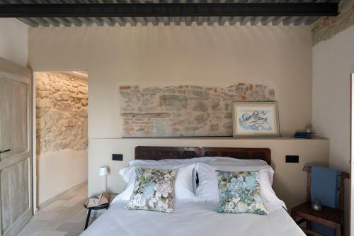 a bedroom with a bed with white sheets and pillows at Lìelà - Ospitalità di borgata in Roccavignale
