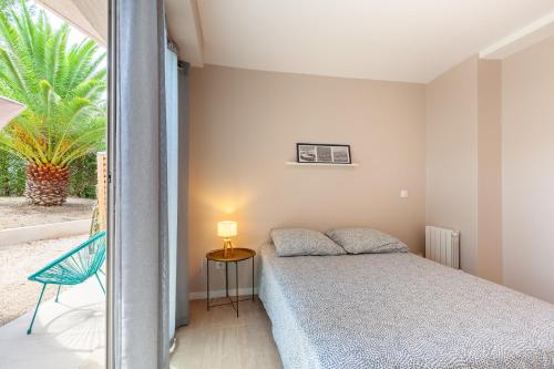Un dormitorio con una cama y una mesa con una lámpara. en Havre de Paix, en Marsella