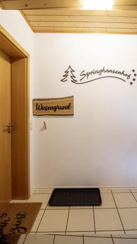 a sign on a wall with a christmas tree on it at Springhansenhof in Oppenau