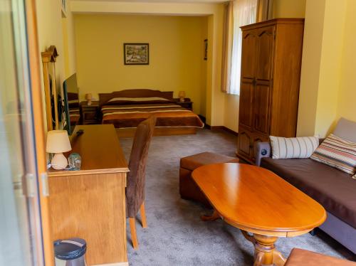 a living room with a couch and a table at Hotel Bozhentsi in Chernevtsi