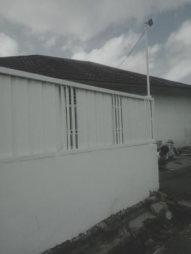 a white fence in front of a house at Rumah Putih Edi in Sengkol