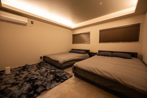 a bedroom with two beds and a rug at 和居 汐羽 モノクロ空間に佇む美邸 ユニバーサルスタジオジャパン近く in Osaka
