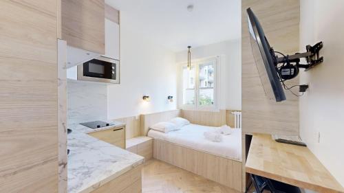 une petite pièce avec un lit et une fenêtre dans l'établissement Bluestay 534 - Superbe appartement à Paris, à Paris