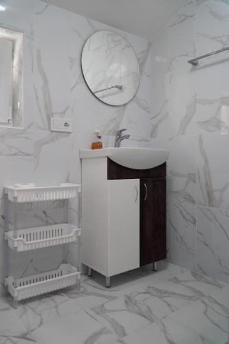 a white bathroom with a sink and a mirror at Yellow House in Pilipets