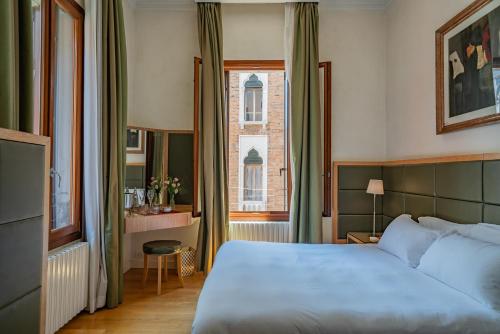 a bedroom with a large bed and a window at Residenza San Marco " La Padrona" in Venice