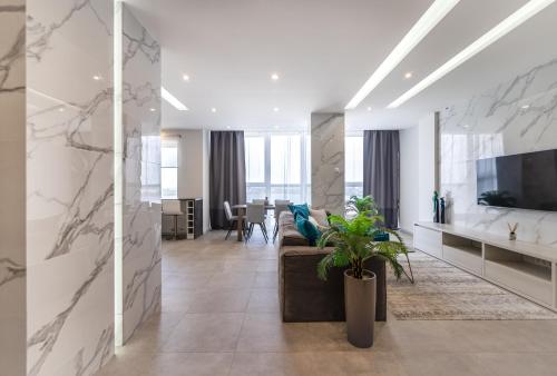 a living room with a couch and a tv at Апартаменты с двумя спальнями с завораживающим видом на Днепр возле Мост Сити in Dnipro