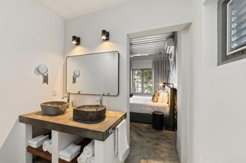 a bathroom with two sinks and a mirror at Appartement Pietermaai met privé zwembad in Willemstad