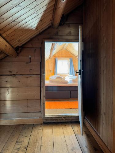 an open door to a bedroom in a wooden house at Toppøy Rorbuer in Reine