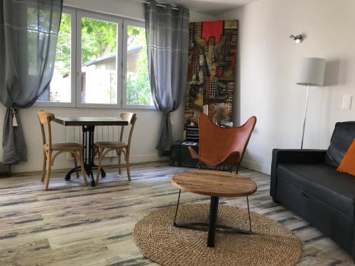 un salon avec un canapé et une table dans l'établissement La vigne vierge, à Saint-Pierre-dʼOléron