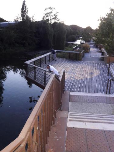 a man standing on a bridge over a river at Le numéro 5 in Bar-le-Duc