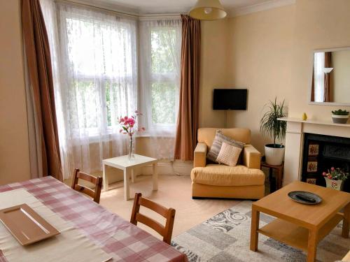 a living room with a couch a chair and a fireplace at Spacious West London 2 Bedroom Apartment in London