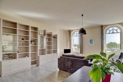 - un salon avec un canapé et des étagères dans l'établissement Le Richelieu - Magnifique duplex avec une vue Incroyable, à Bordeaux