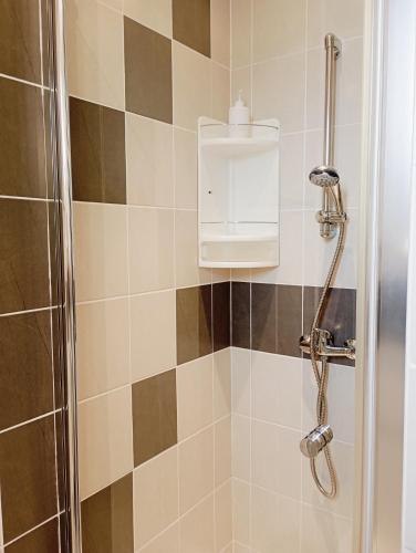 La salle de bains est pourvue d'une douche et d'un distributeur de savon. dans l'établissement Grand appartement proche port et plages, 6 à 8 pers, 3 chambres, climatisé, au Cap d'Agde